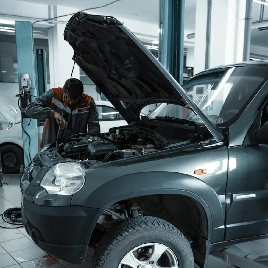A mechanic inspecting the engine of the car with the bonnet open