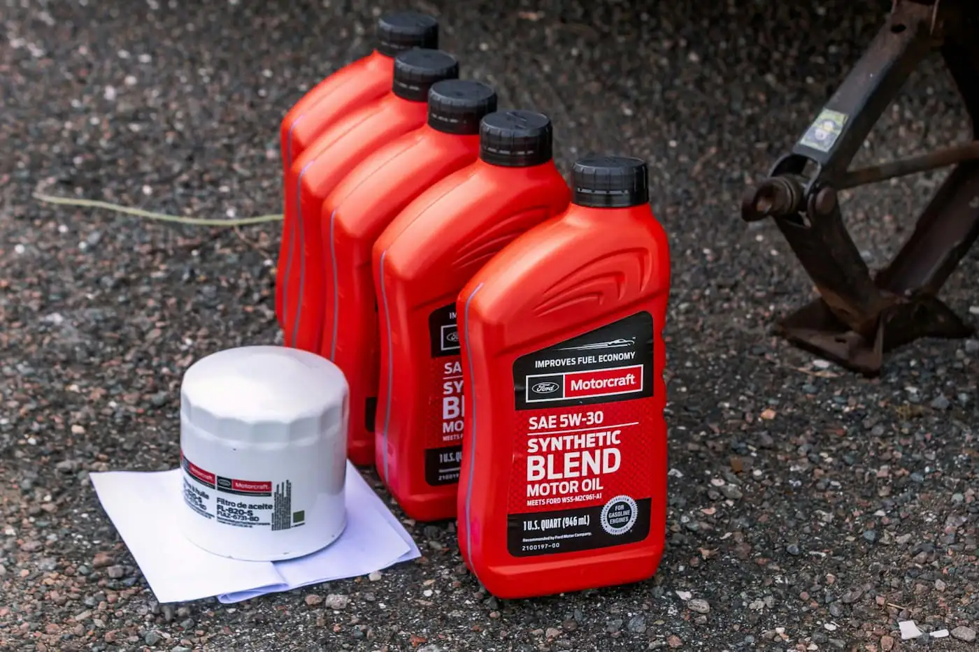 Bottles of synthetic motor oil and an oil filter on the ground