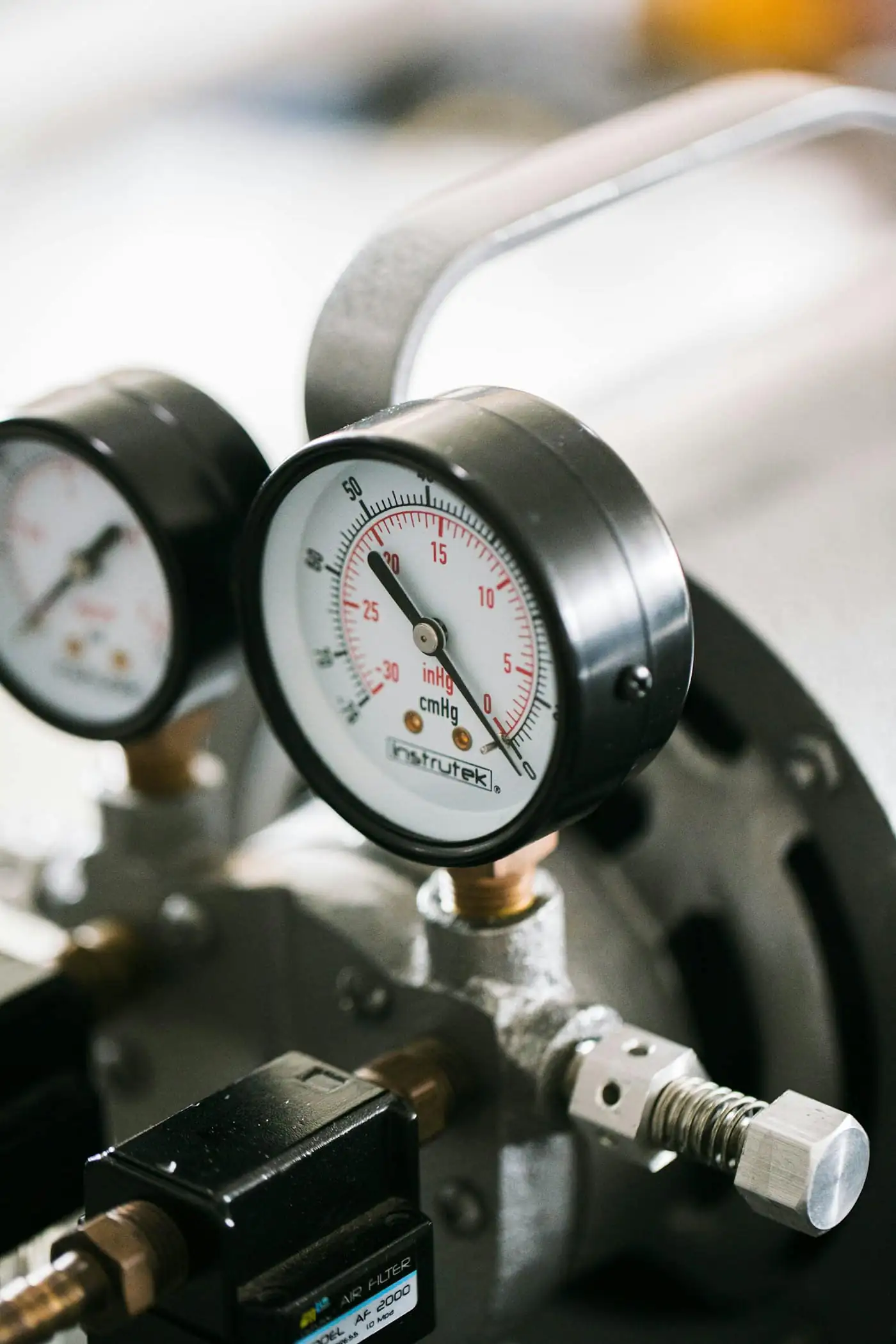Two refrigerant pressure gauges on a service machine