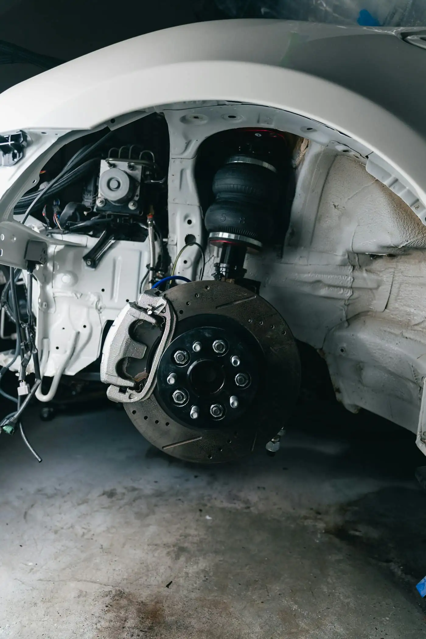 A front suspension strut and brake assembly with the wheel removed